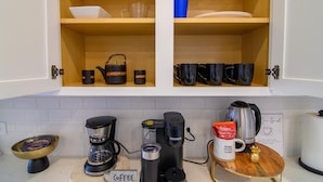 A kitchen with two open cabinets, a coffee station, and a sign reading 'HOME SWEET HOME'. -     Spacious Katy TX  one story Home / 4 Bedrooms + Hot Tub (Katy)