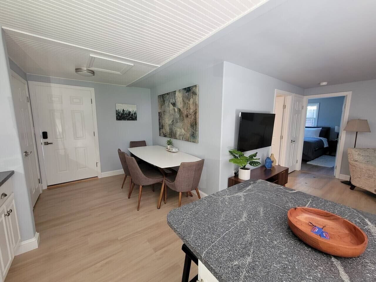 Una cocina moderna con comedor, televisor de pantalla plana y un amplio ventanal.