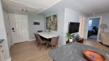 Una cocina moderna con comedor, televisor de pantalla plana y un amplio ventanal.