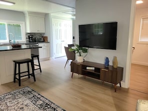 A modern kitchen with a dining area, a flat-screen TV, and a potted plant. - The Nature Preserve in Portsmouth (Portsmouth)