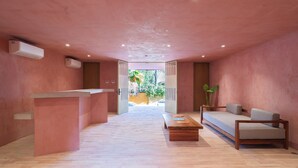 A modern interior with a reception desk, a sofa, and a coffee table. - Laiva Artwalk by Tasman (San José del Cabo)