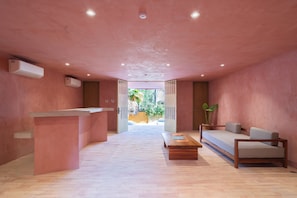 A modern interior with a reception desk, a sofa, and a coffee table. - Laiva Artwalk by Tasman (San José del Cabo)