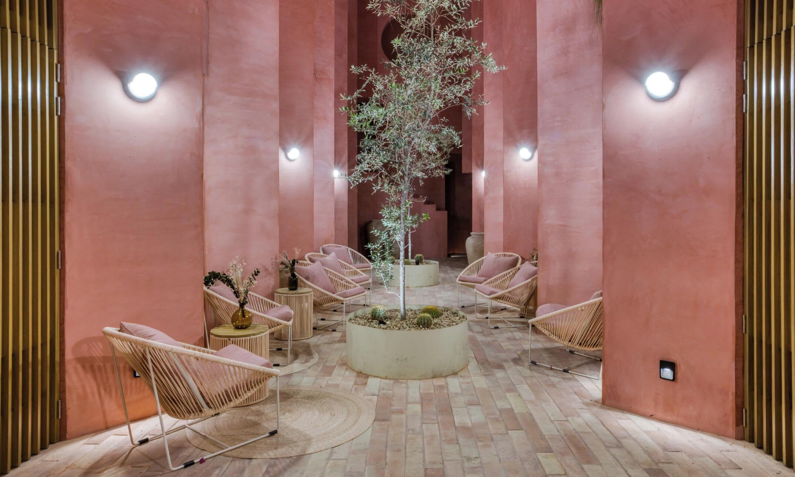A lobby with a central tree, seating arrangements, and a patterned floor.