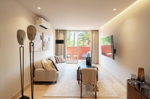 Una sala de estar moderna con un sofá, una mesa de centro y un televisor montado en la pared.