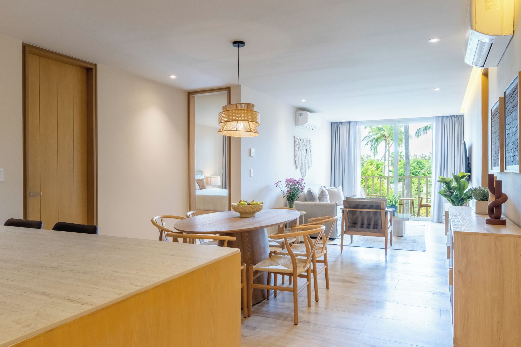 Un salón moderno con comedor, ventanas amplias y vistas a zonas verdes.
