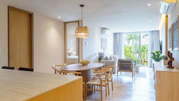 Un salon moderne avec un coin repas, de grandes fenêtres et une vue sur la verdure.