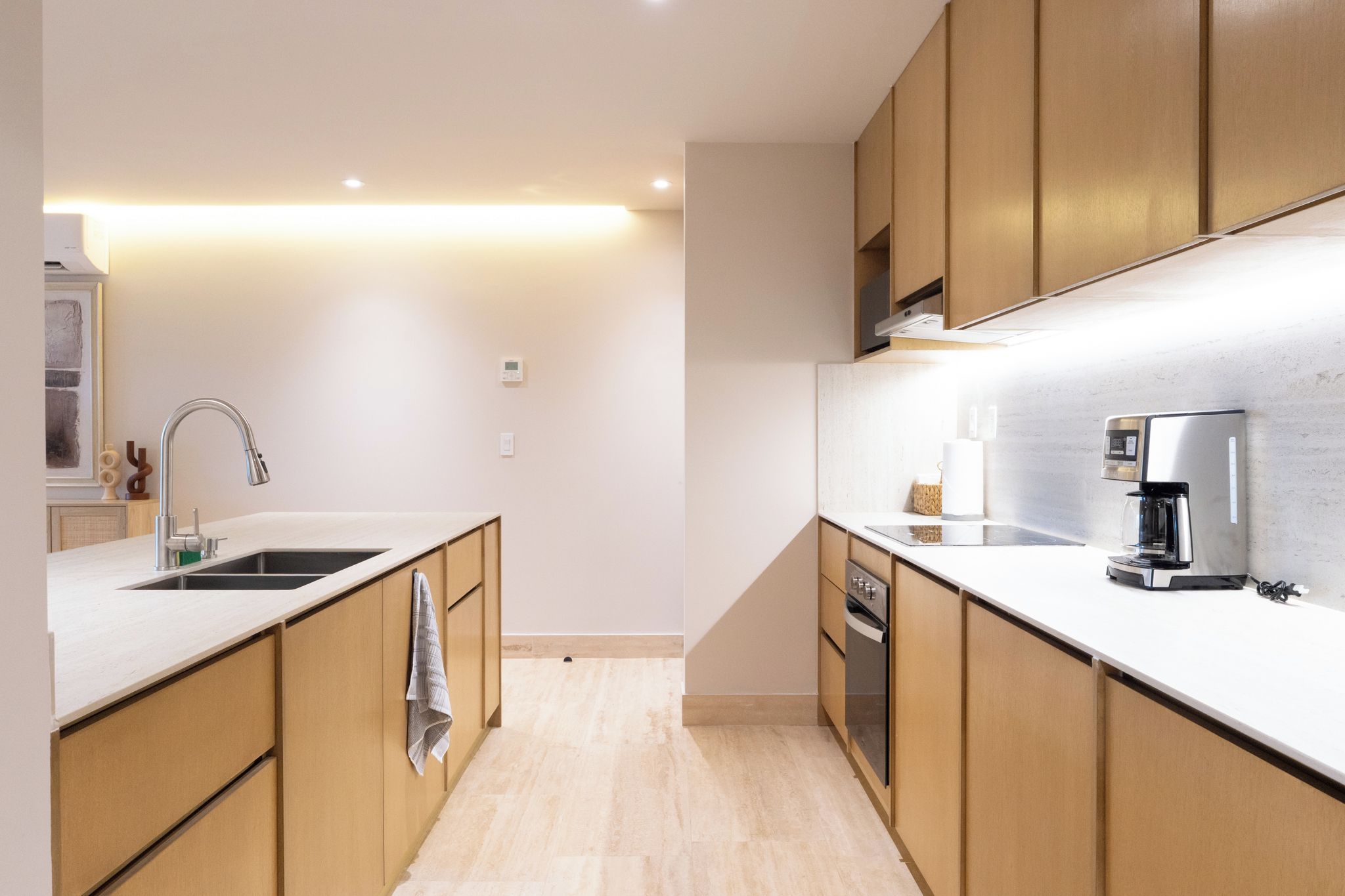 Een moderne keuken met houten kastjes, een roestvrijstalen spoelbak en een inbouwoven.