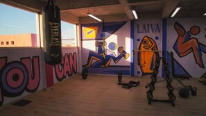 A gym with a punching bag, exercise equipment, and motivational wall art. - Laiva Artwalk by Tasman (San José del Cabo)