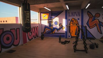A gym with a punching bag, exercise equipment, and motivational wall art.