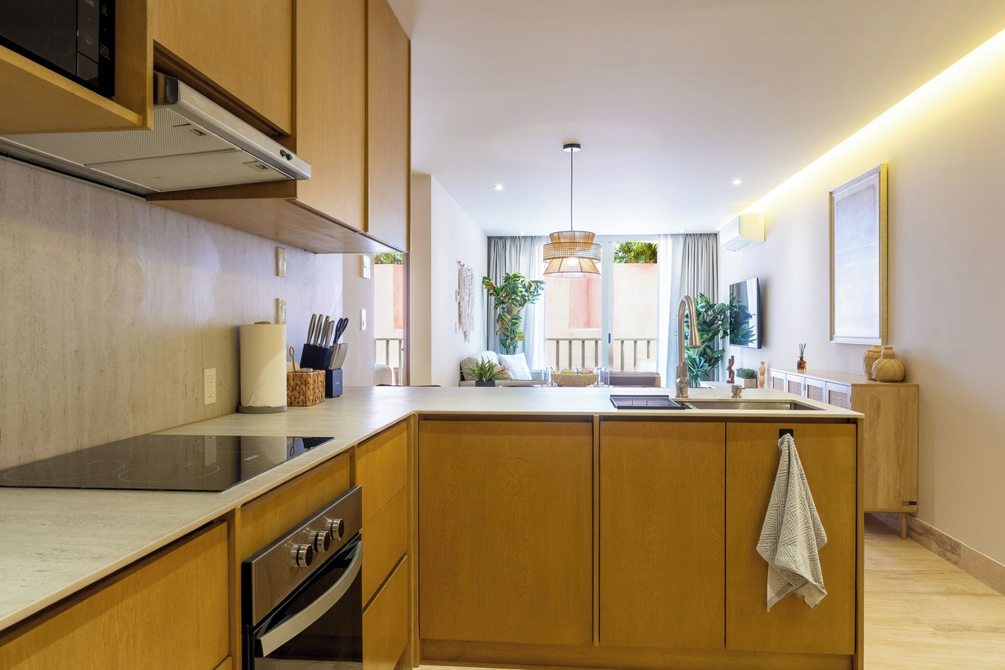 Een moderne keuken met houten kastjes, een inbouwoven en een centraal eiland.