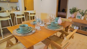 Un comedor con una mesa de madera dispuesta para una comida, rodeado de sillas.