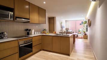 Een moderne keuken met houten kastjes, een inbouwoven en een groot kookeiland met spoelbak.
