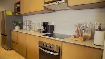 A modern kitchen with stainless steel appliances, wooden cabinets, and a variety of kitchenware.
