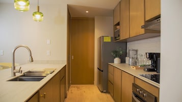 Una cocina moderna con electrodomésticos de acero inoxidable, gabinetes de madera y un horno empotrado.