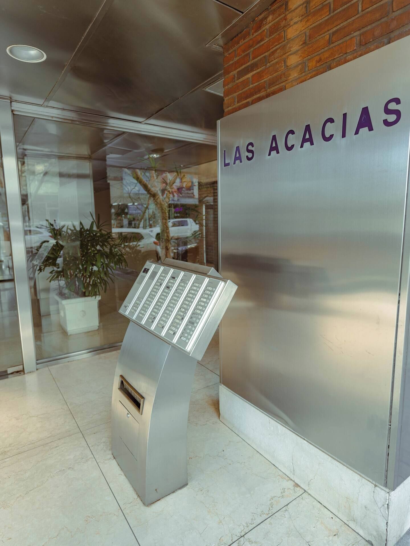 A reception area with a modern kiosk and a wall with 'LAS ACACIAS' signage.