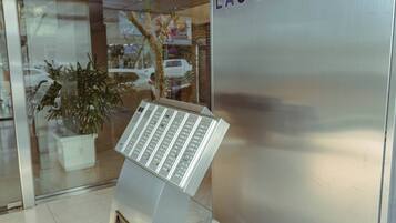 A reception area with a modern kiosk and a wall with 'LAS ACACIAS' signage.