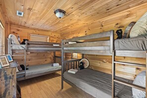 A bunk bed room with wooden walls and floors, a ceiling light, and a small table with a teddy bear. - Hoot Owl Lodge - Views, Bark Park, Arcade, Hot Tub (Blue Ridge)