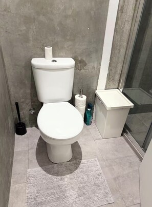 A bathroom with a toilet, a hand dryer, and a trash bin. - Apartment in Bairro Alto (Lisboa)