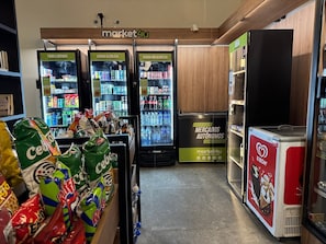 Ein Marktgang mit gekühlten Getränkeautomaten, Snacks und einem Gefriertruhe.