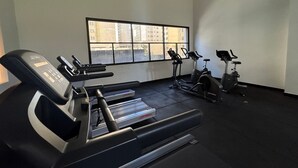 A gym with treadmills, stationary bikes, and a weight bench. - Studio próximo a Sirio Libanês  (São Paulo)
