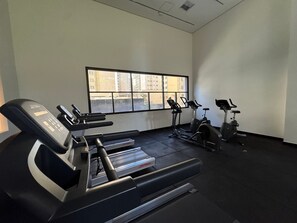 Ein Fitnessstudio mit Laufbändern, Ergometer und einer Gewichtbank.