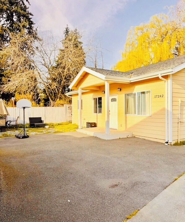 A single-story building with a covered porch, a basketball hoop, and a number '17242' on the side. - Charming 2-bedroom house with AC in awesome SeaTac neighborhood (SeaTac)