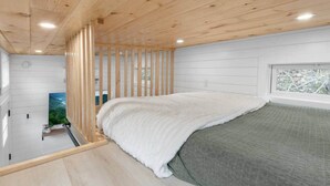 Una camera da letto con un letto, una finestra e vista sul verde.