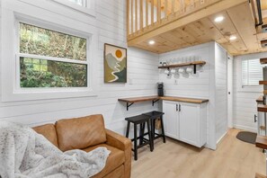 A modern interior with a kitchen, a dining area, and a living room with a sofa and a coffee table.