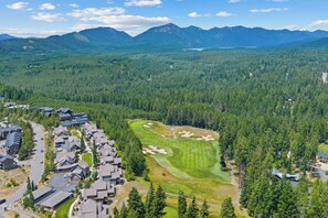 Ein Wohngebiet mit Häusern, einem Golfplatz und einem Bergpanorama.