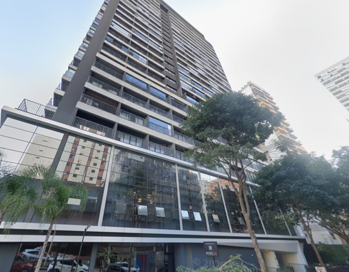A modern high-rise building with multiple balconies and a glass facade.