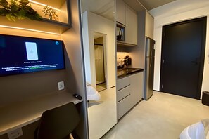 Una cocina moderna con horno empotrado, cafetera y refrigerador.