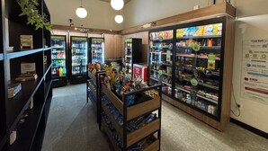 Ein Supermarkts Inneres mit Kühlregalen, Snackregalen und einer Holztruhe.
