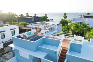 A rooftop terrace with outdoor seating, a pool, and a view of the ocean. - Beach House! Rooftop Lounge in San Juan Walk Half block to beach Incrdible value (San Juan)