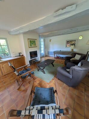 A living room with a sofa, armchair, and a television. - La Passée – House in Sainte-Marguerite-sur-Mer (Sainte-Marguerite-sur-Mer)