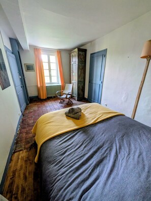 A bedroom with a bed, a chair, a radiator, and a window with curtains. - La Passée – House in Sainte-Marguerite-sur-Mer (Sainte-Marguerite-sur-Mer)
