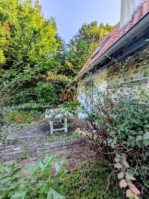 A rustic building with a sloped roof, surrounded by dense greenery and a wooden deck. - La Passée – House in Sainte-Marguerite-sur-Mer (Sainte-Marguerite-sur-Mer)