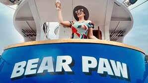 A person standing on a boat deck with the text "BEAR PAW" and a paw print logo.