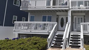 A two-story building with a balcony, a front door, and a flag. - 3BDRM Brigantine home near beach - 2026 Open Weeks: 7/25 and 8/22 (Brigantine)