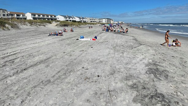 A sandy beach with beach chairs and umbrellas, a few people, and buildings in the background. - 3BDRM Brigantine home near beach - 2026 Open Weeks: 7/25 and 8/22 (Brigantine)