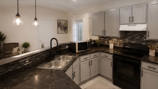 A modern kitchen with a black marble countertop, stainless steel sink, and white cabinetry. - Spacious 4-bedroom house in wonderful Kissimmee with AC (Kissimmee)