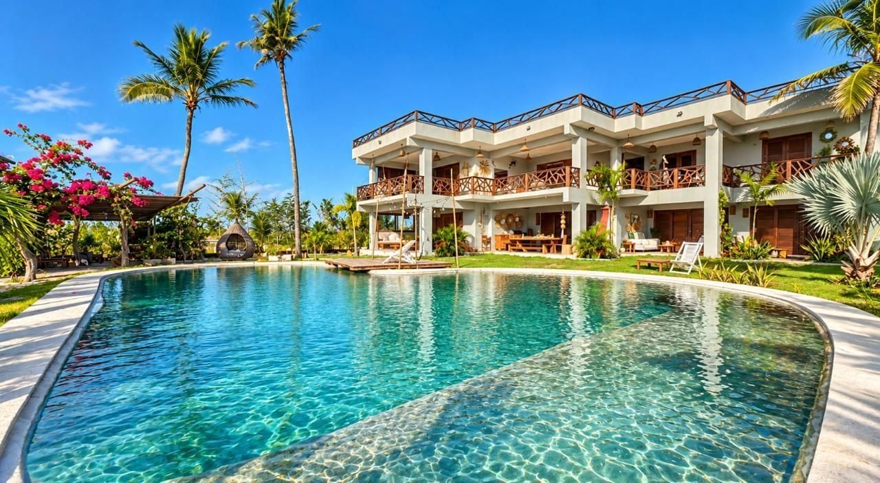 Un resort con piscina, varios balcones y exuberante jardinería tropical.
