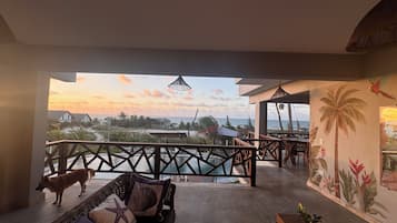 Uma varanda com vista para o mar e um cão.