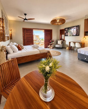 A modern bedroom with a bed, a desk, and a dining area. - refugio prea (Cruz)