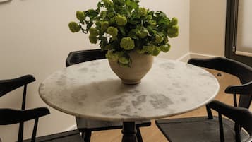 Een ronde tafel met een plant in het midden, omringd door vier stoelen.