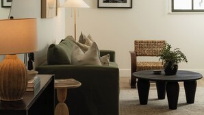 A modern living room with a sofa, a coffee table, a lamp, and a chair.