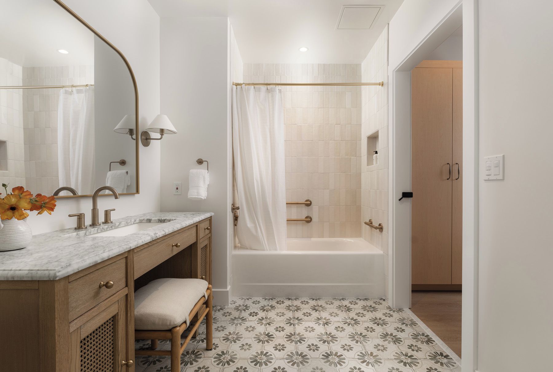 A modern bathroom with a marble sink, a bathtub, and a shower area.