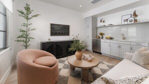 A modern living room with a sofa, a round coffee table, and a potted plant.