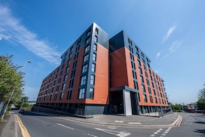 A modern multi-story building with a prominent entrance, likely a hotel or office complex. - Sleek 2-Bed Salford Apartment near City Centre (Salford)