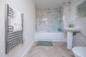 A bathroom with a shower, a sink, and a toilet. - Sleek 2-Bed Salford Apartment near City Centre (Salford)