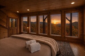 A bedroom with a large bed, multiple windows, and a view of autumn foliage. - Marvelous Views! Hot tub, Air Hockey, Location, Fire Pit- This Cabin Has It All! (Sevierville)